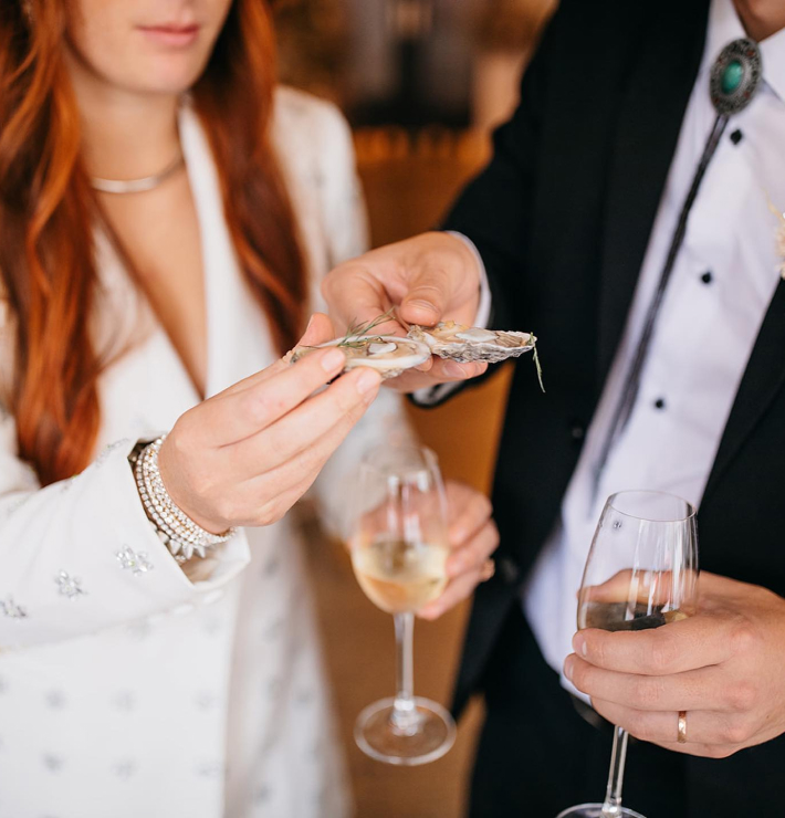 A couple cheersing oysters during private dining in Chattanooga.